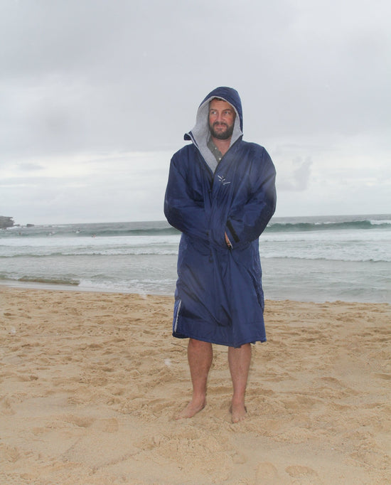 Stay warm Toasty Ultimate changing jacket in Navy worn on the beach in bad weather
